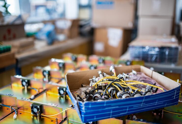 connecting-cords-with-metal-plugs-contemporary-tft-monitors-cardboard-box-production-plant-workshop-extreme-close-view_212944-18603